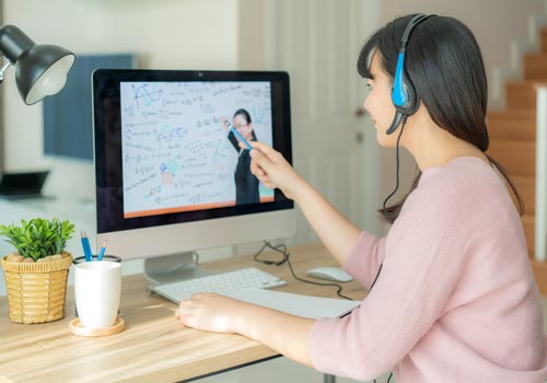 Девушка проводит онлайн обучение с учителем на компьютере