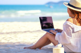 Девушка работает за ноутбуком на красивом пляже